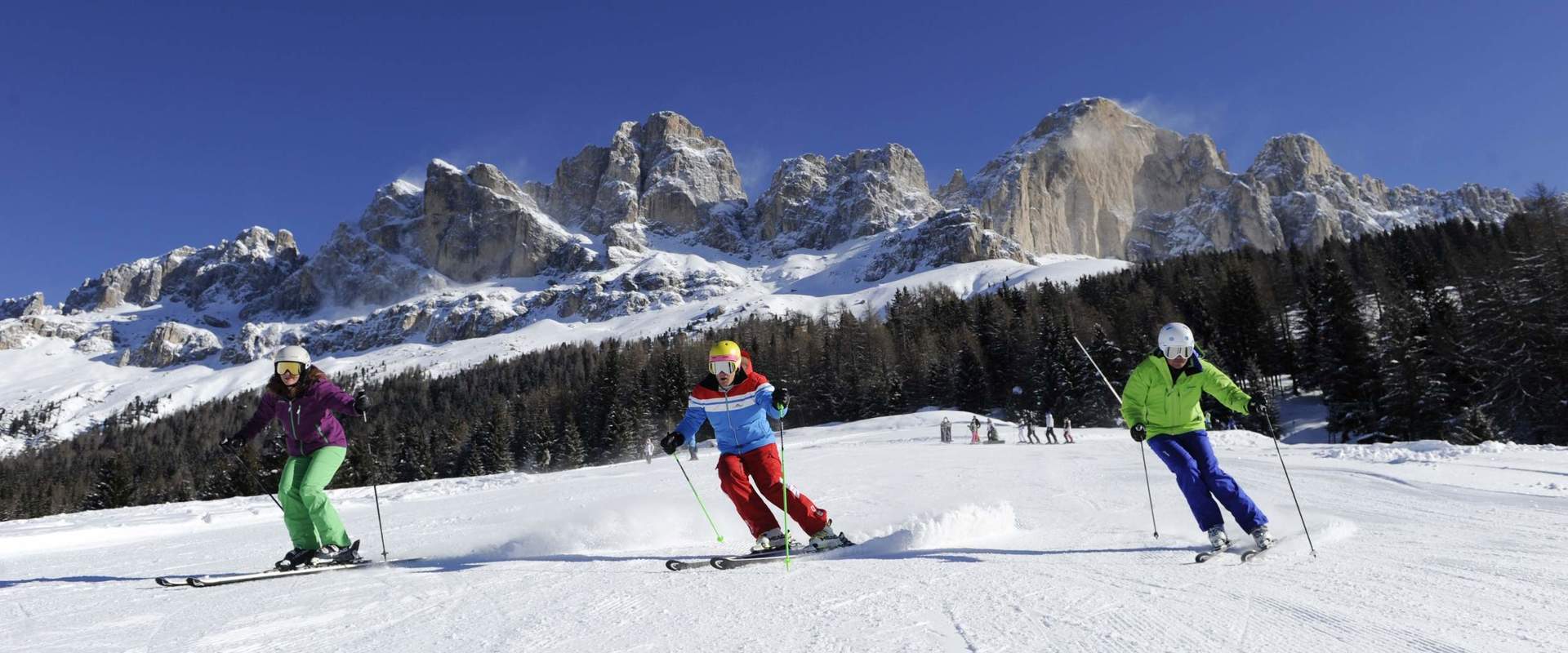 Skiers on prepared slope in Eggental Valley at the foot of Mt. Rotwand