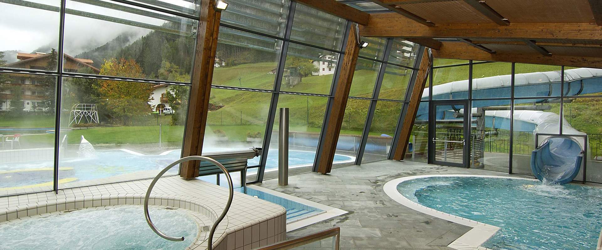 Indoor and outdoor swimming pool with slide.