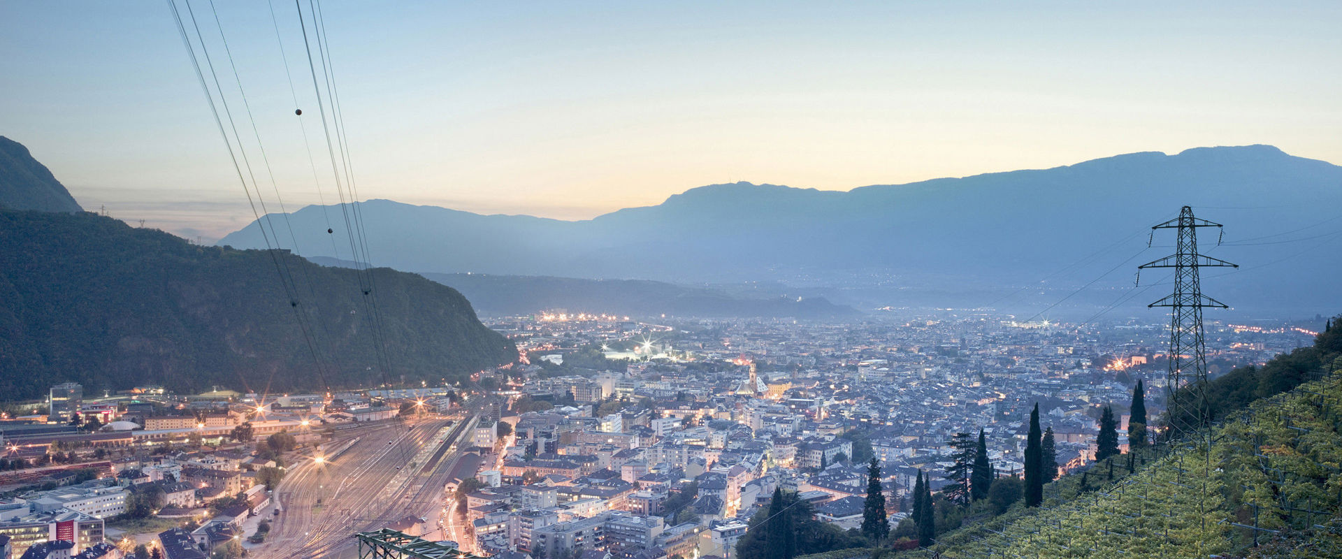 Town illuminated in the early evening, lined with vineyards.