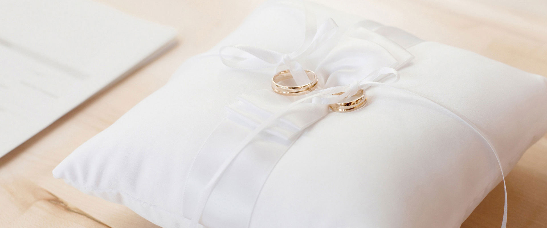 Pillow with 2 golden wedding rings.