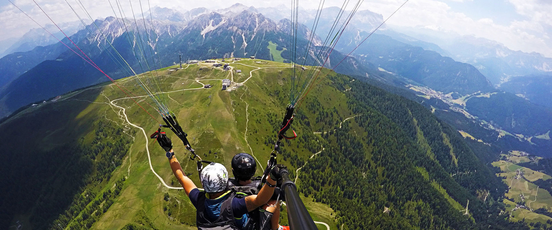 Paragliding mount Kronplatz in summer. Tandem paragliding over mount Kronplatz Plan in summer.