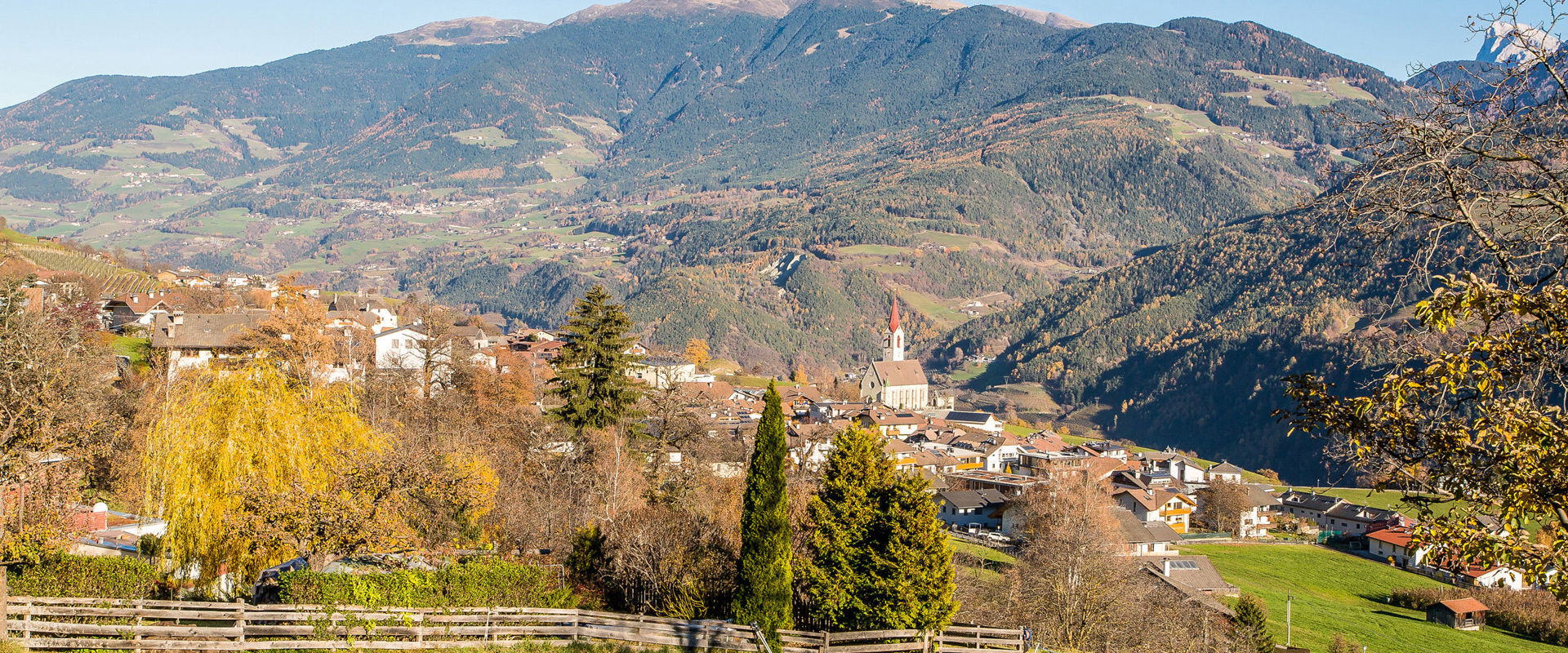 Feldthurns with parish church in autumn & view to Mt. Plose