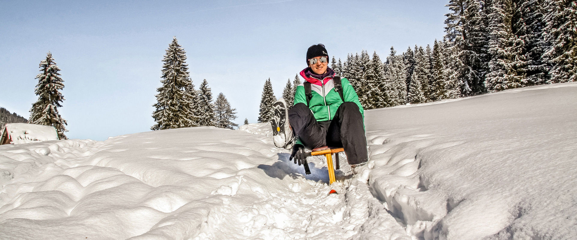 Woman riding down the snow-covered mountain with the Rennböckl.