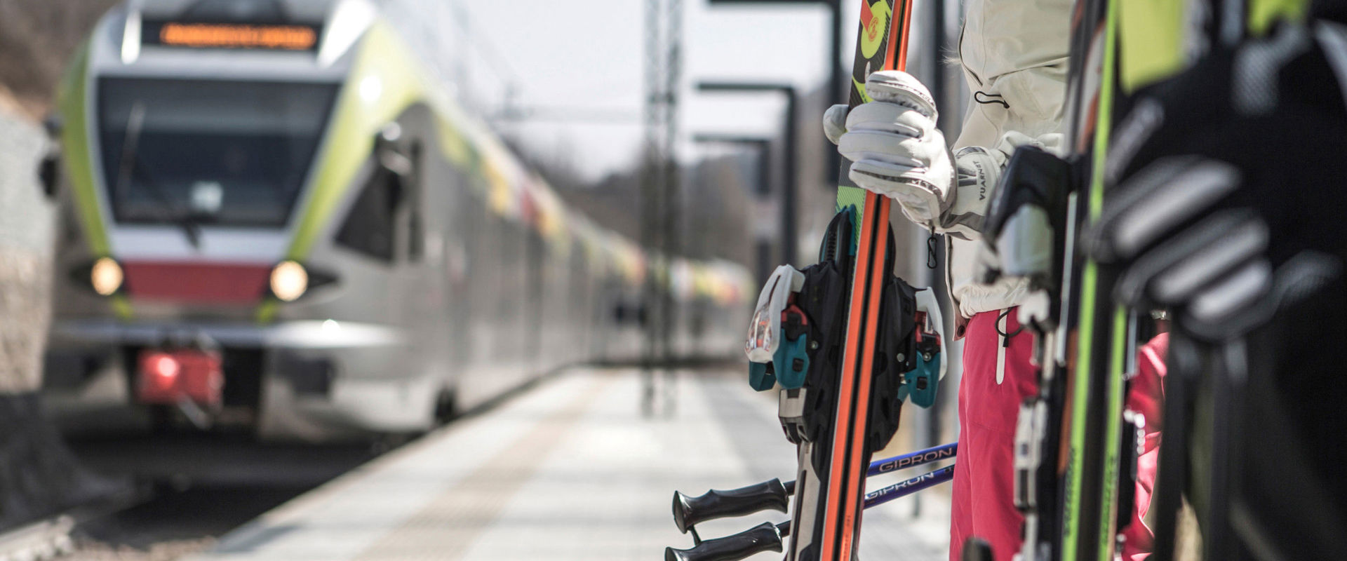 Travelling by train in winter Skiers wait on the platform while the train arrives at the station.
