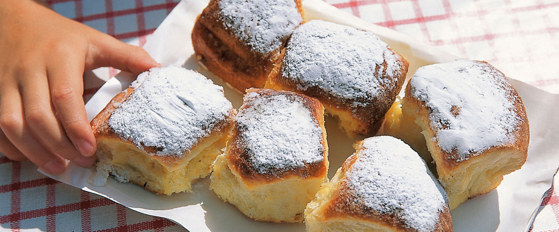 One hand reaches for the buns on the table.