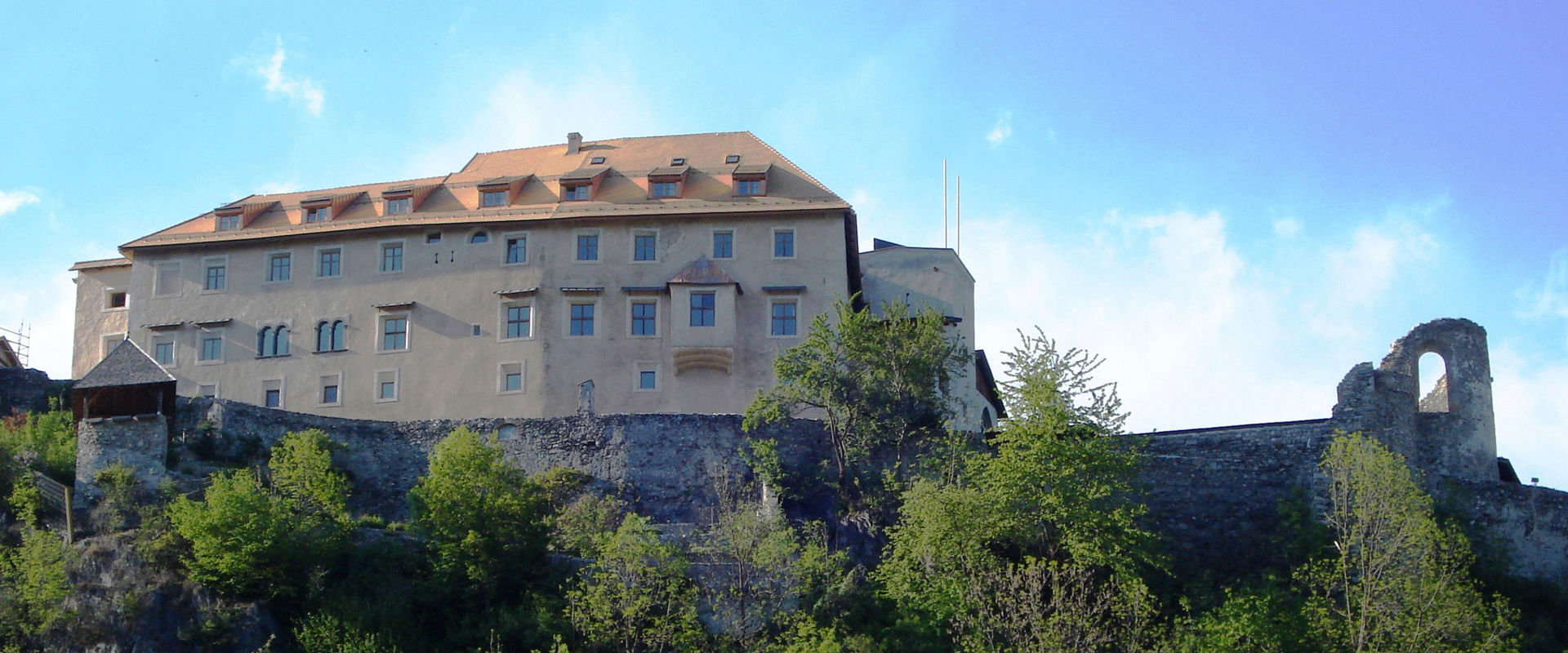 Sonnenburg Castle with its steep castle walls in the middle of the greenery.
