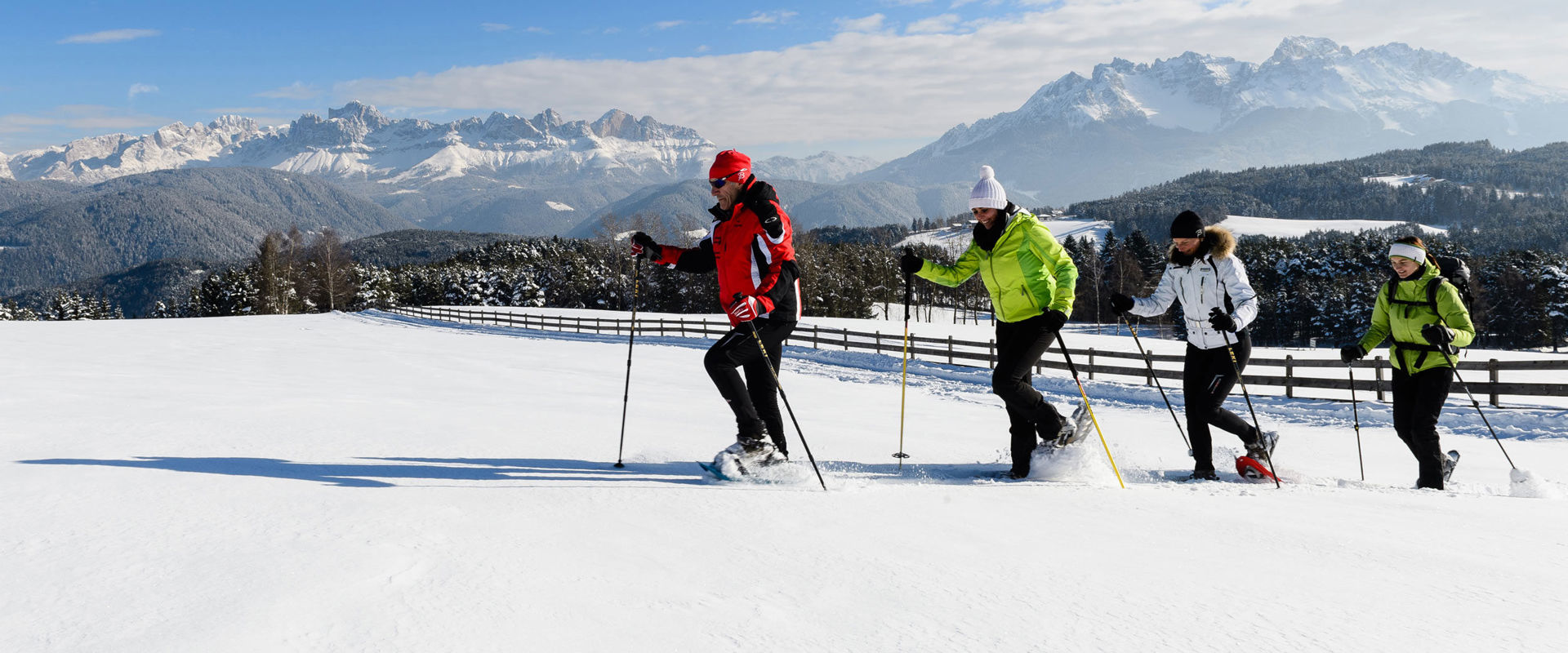 Snowshoe hikers in new snow with Dolomites scenery