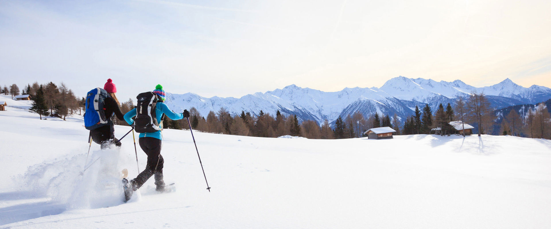 Two snowshoe hikers in the wintry mountain landscape.