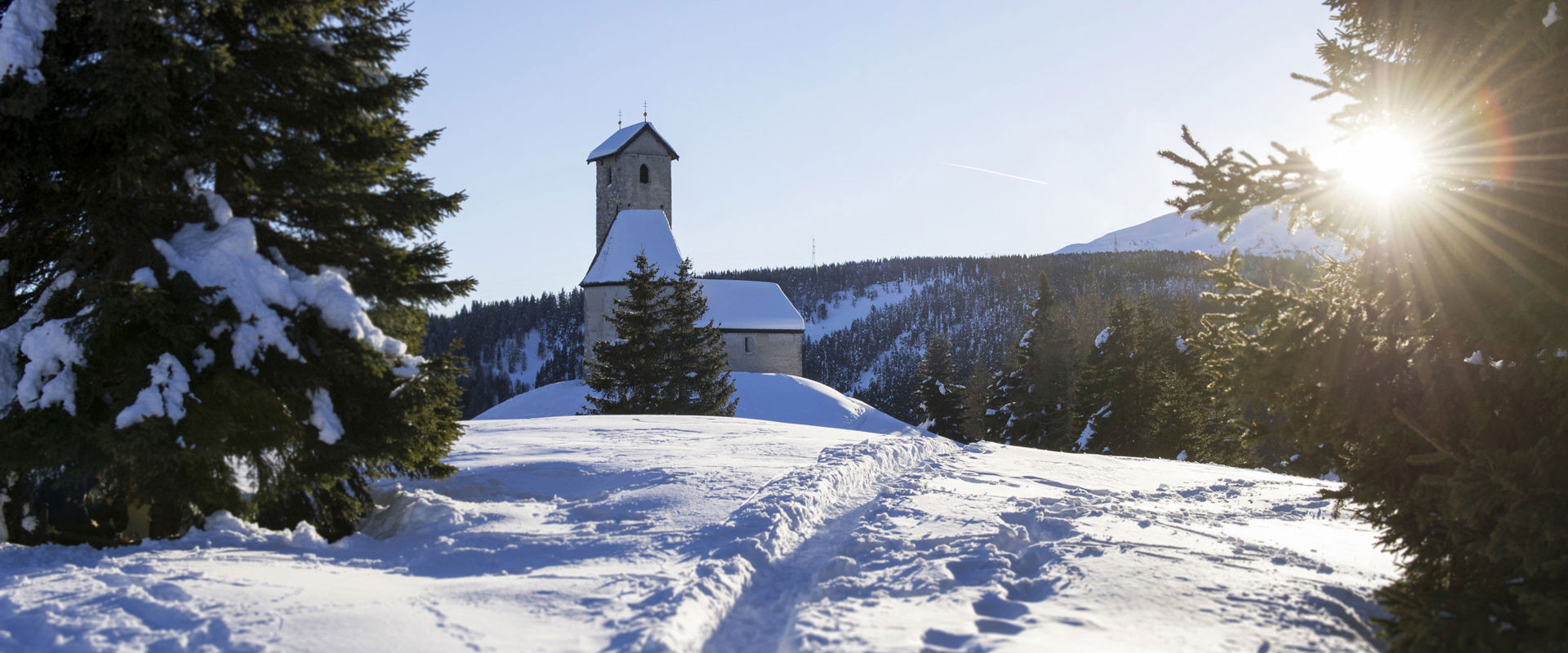 Small church in the middle of a white, snowy landscape.