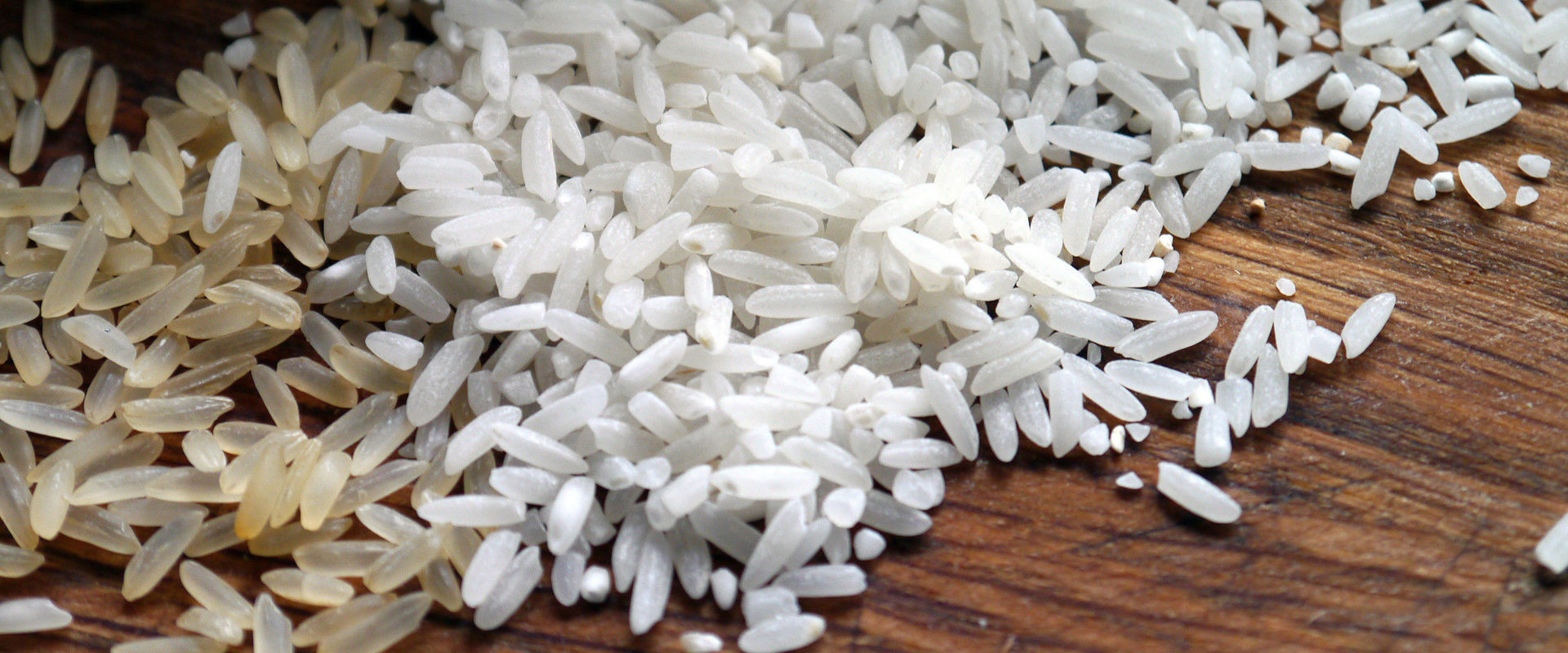 Spilt rice on a wooden table.