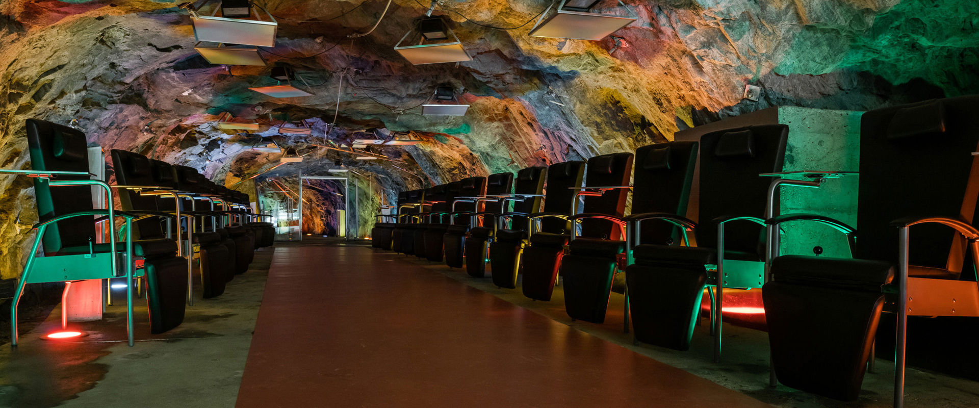 Climatic gallery Prettau Several red armchairs are arranged in the gallery one after the other.
