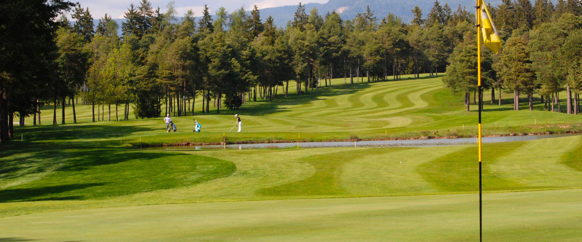 Dolomiti Golf Club Golf course with 2 golfers.