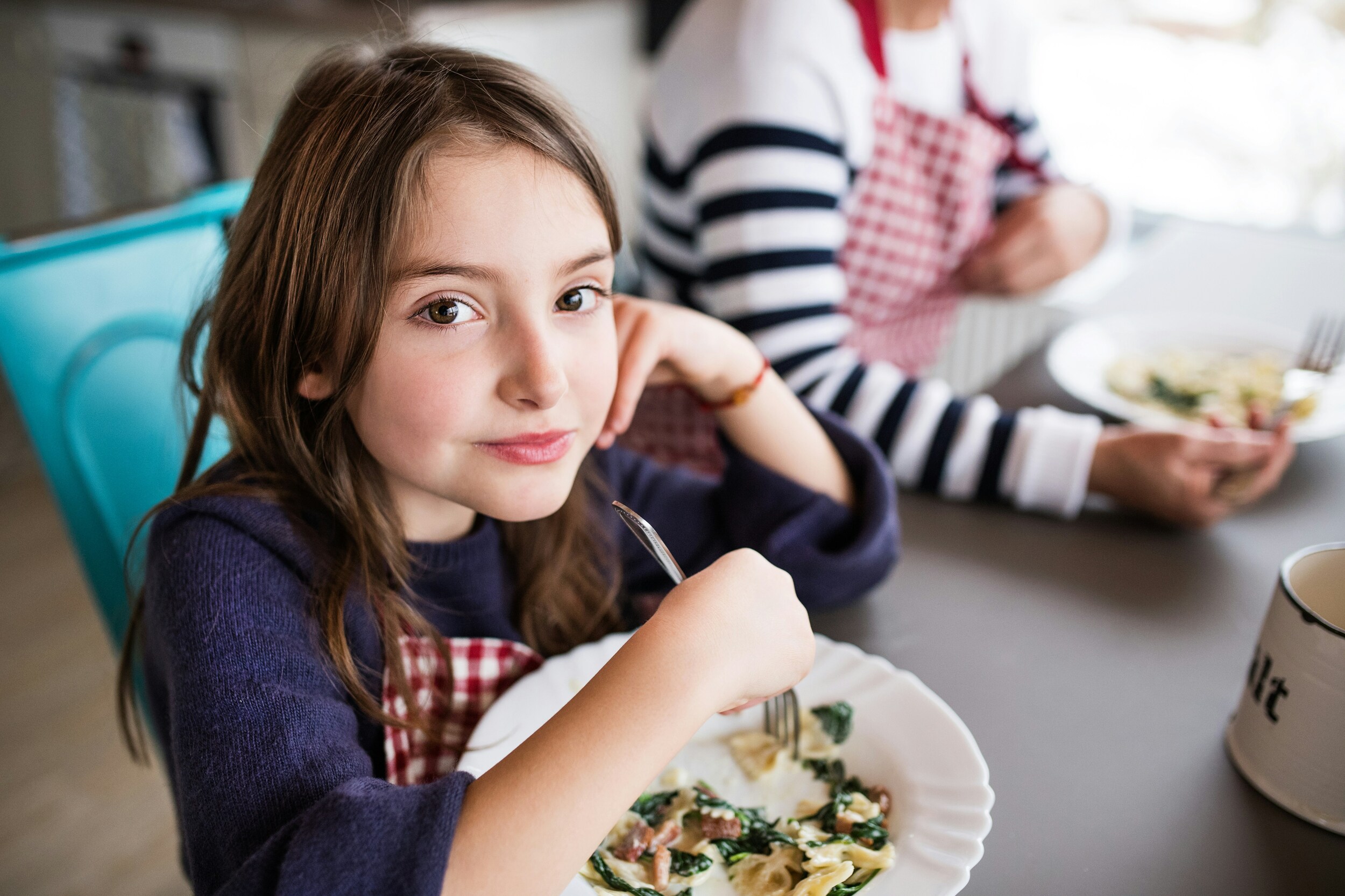 Children sitting at a table to eat something.