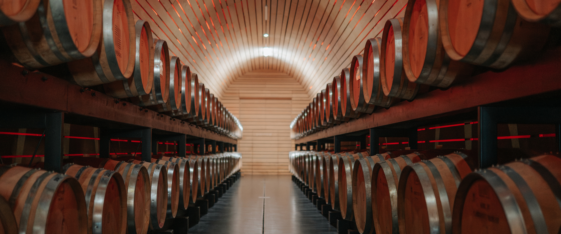 Wine barrels stacked up on the left and right in a new wine cellar