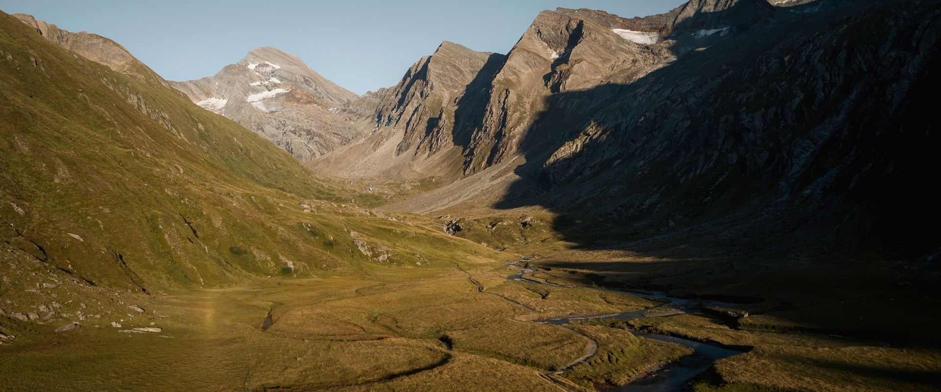 Winding river in high moor with mountain peaks in the evening light