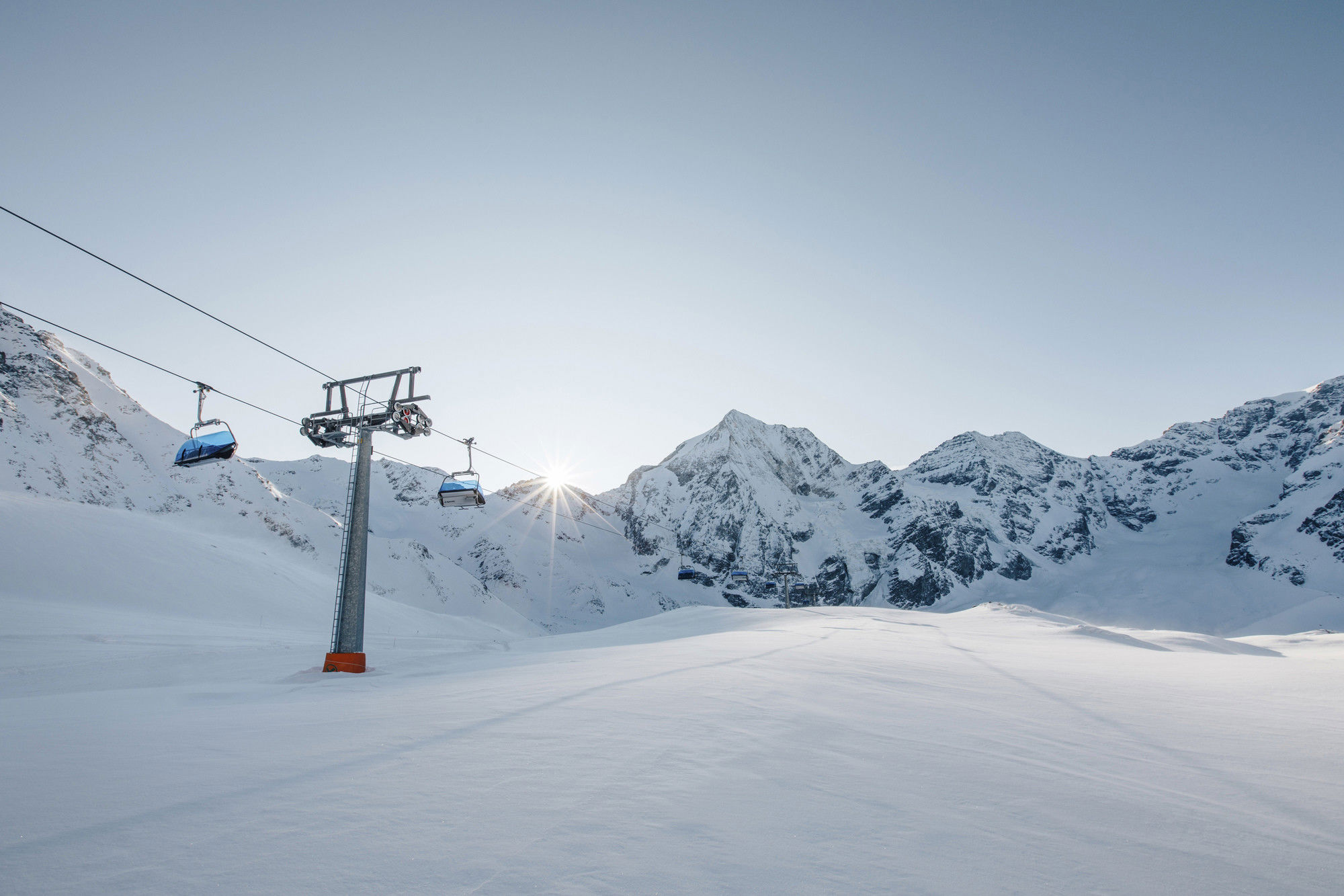 Chairlift with freshly snow-covered mountain landscape.