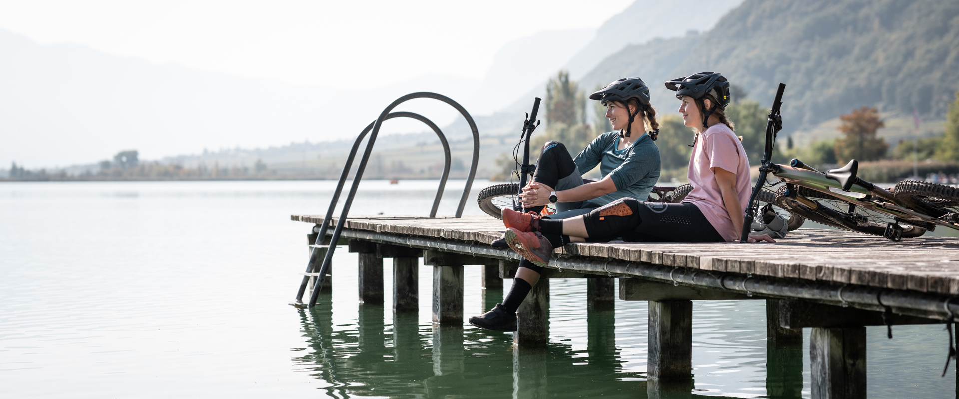 2 cyclists on the jetty of a lake in South Tyrol