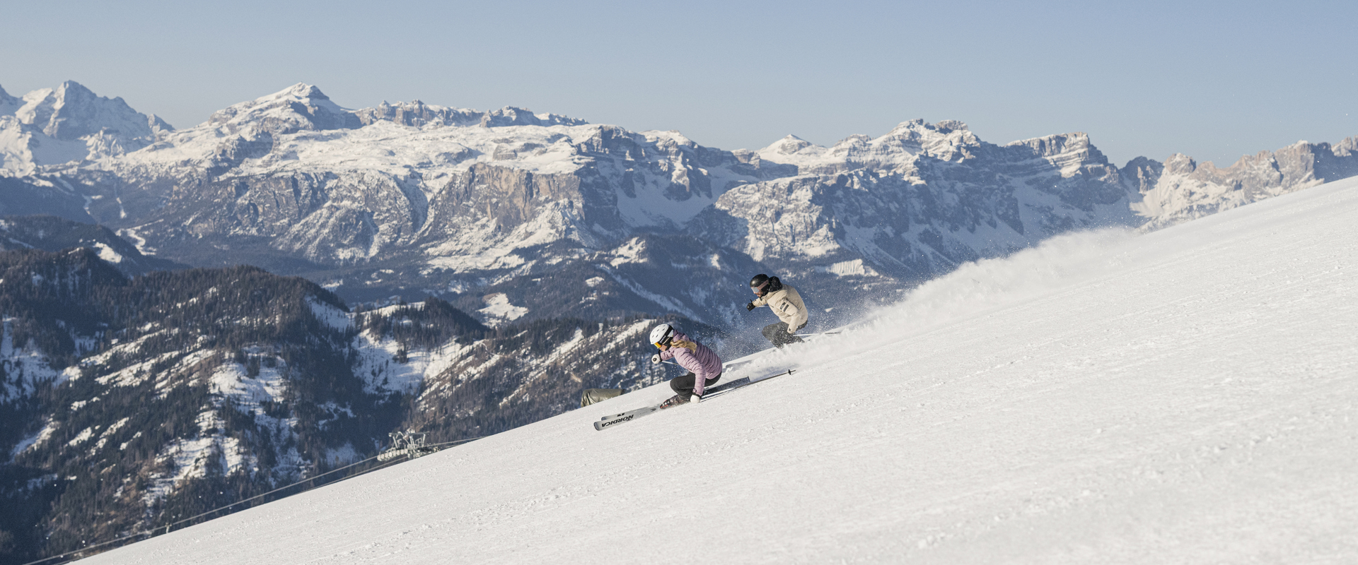 2 skiers ride down the freshly prepared slope.