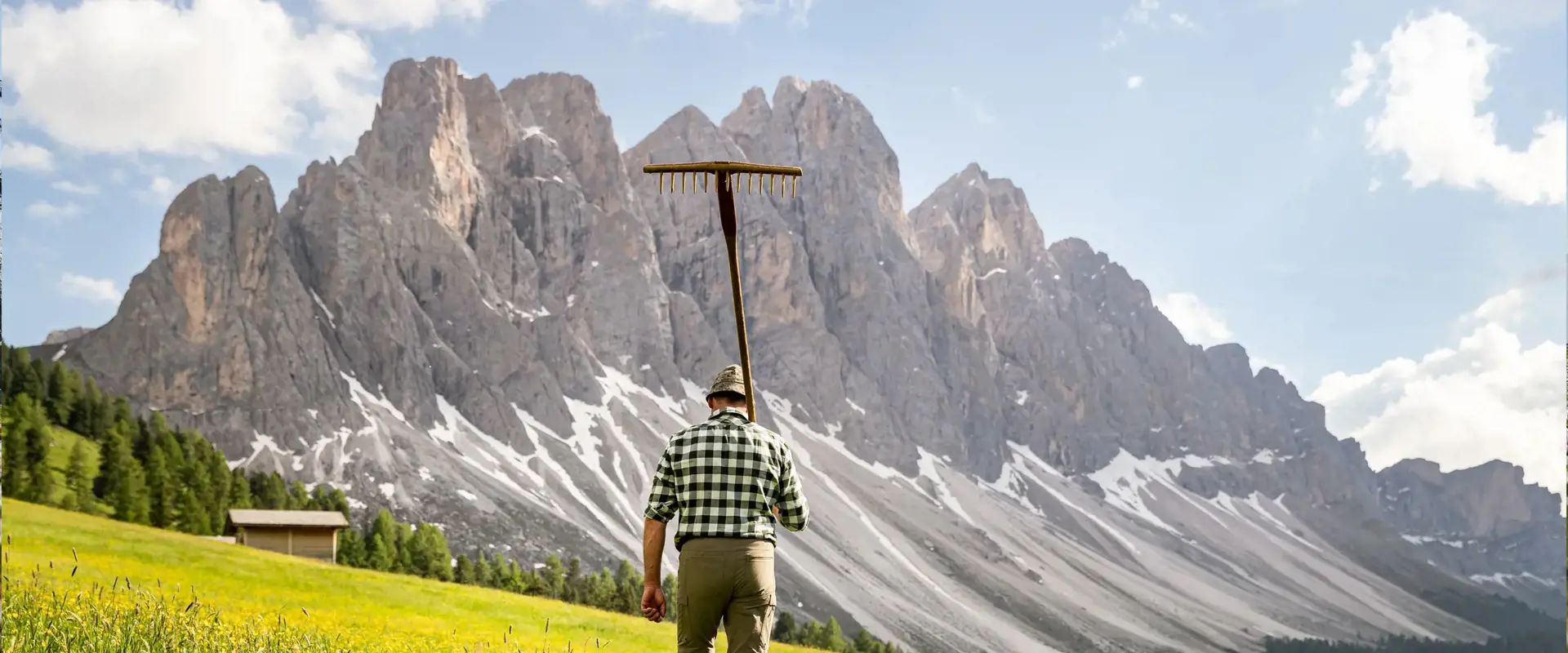 Mountain farmer with pitchfork in the alpine meadow.
