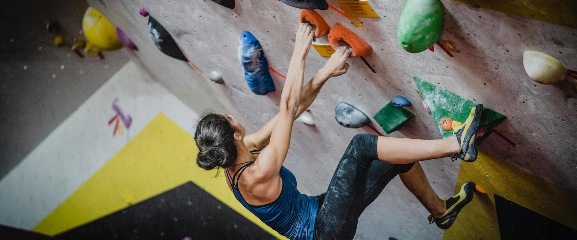 Woman bouldering in a climbing gym in South Tyrol.