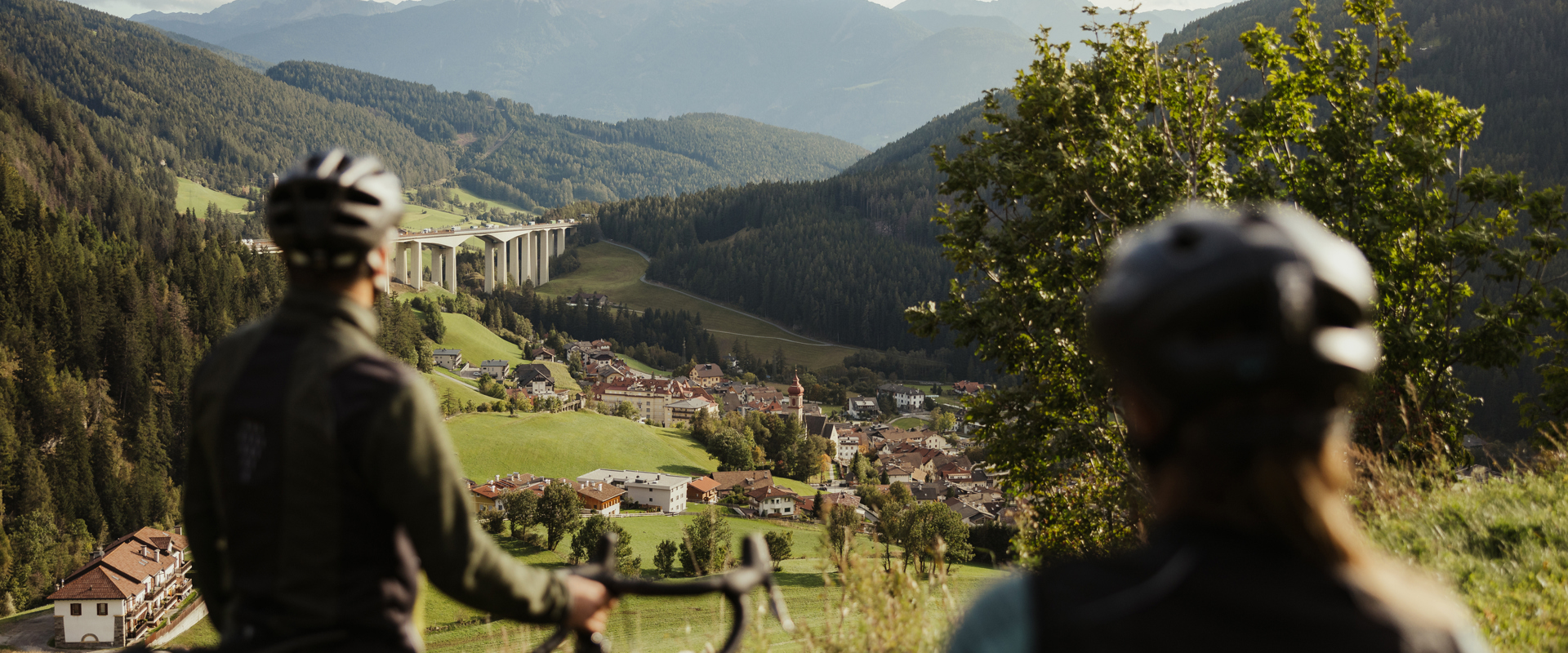 Two cyclists look towards Gossensass