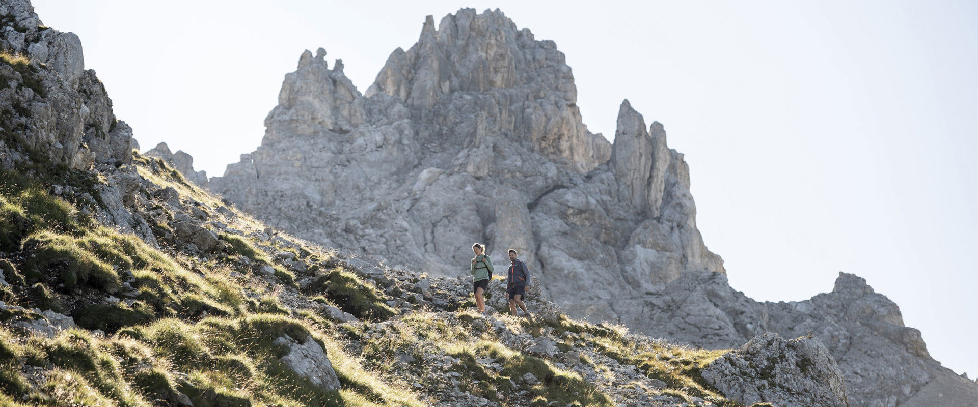 Hiking in Obereggen Two hikers with the Gamsstallscharte, a loophole in Obereggen, in the background.