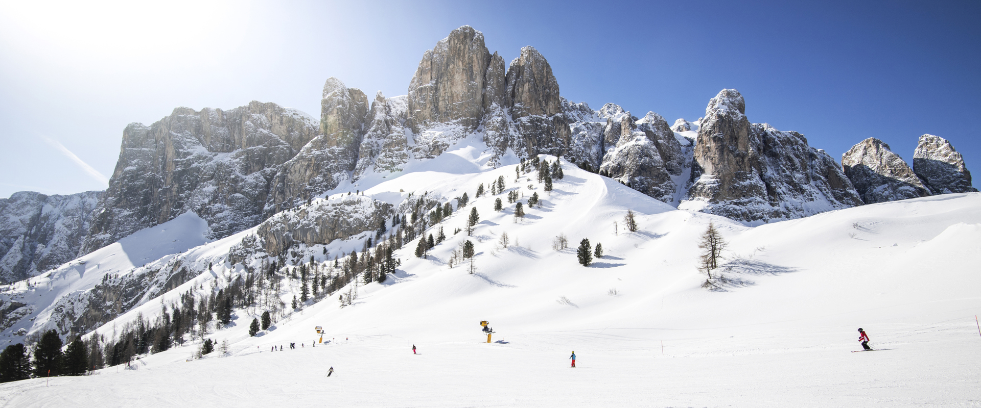 Skiing in bright sunshine with Dolomite peaks